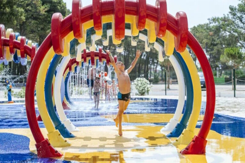 Kinderen op de waterspeelplaats van de camping